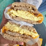 A sausage, egg, and cheese breakfast sandwich cut in half to show the cross section.