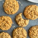 A closeup shot of multiple chewy oatmeal cookies with one cookie having a bite taken out of it.