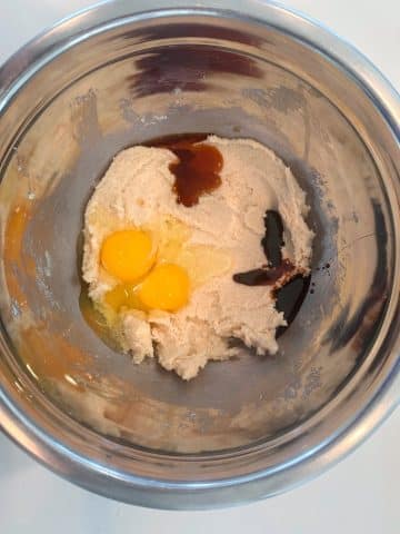 An ingredient shot for chewy oatmeal cookies, including creamed butter and sugar, eggs, and vanilla.