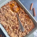 A baking pan containing carrot soufflé with crumble topping.