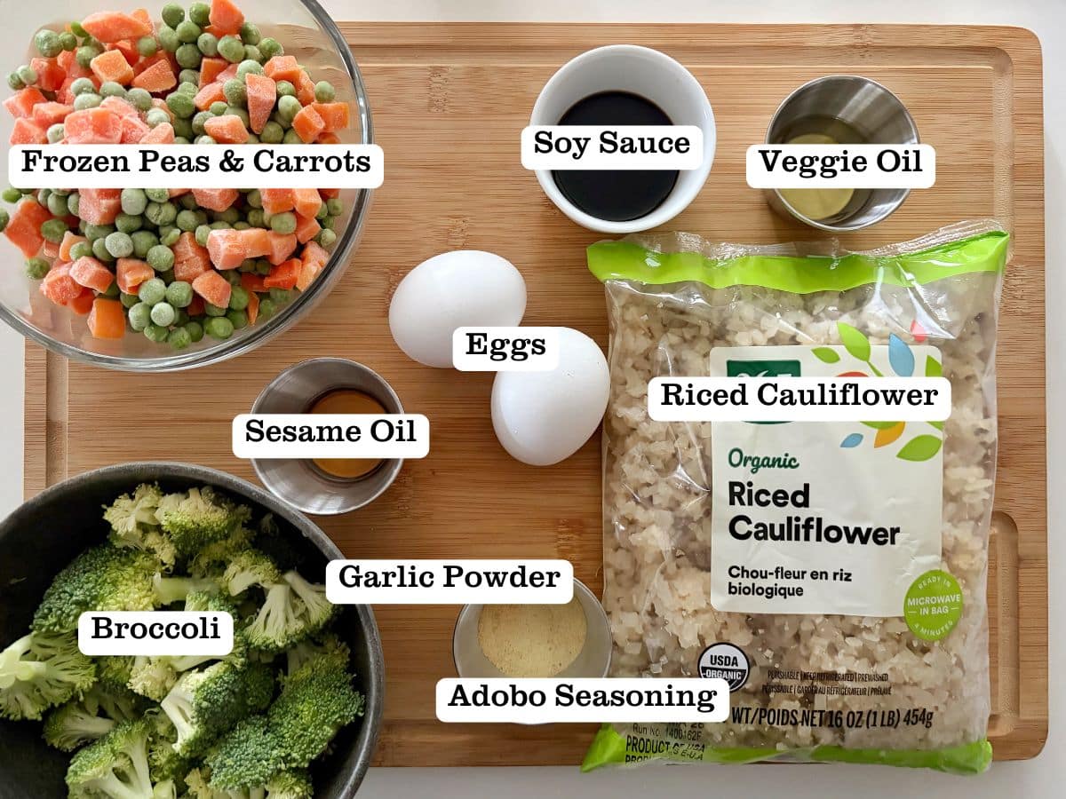 A wooden board with containers of ingredients to make fried rice out of cauliflower.