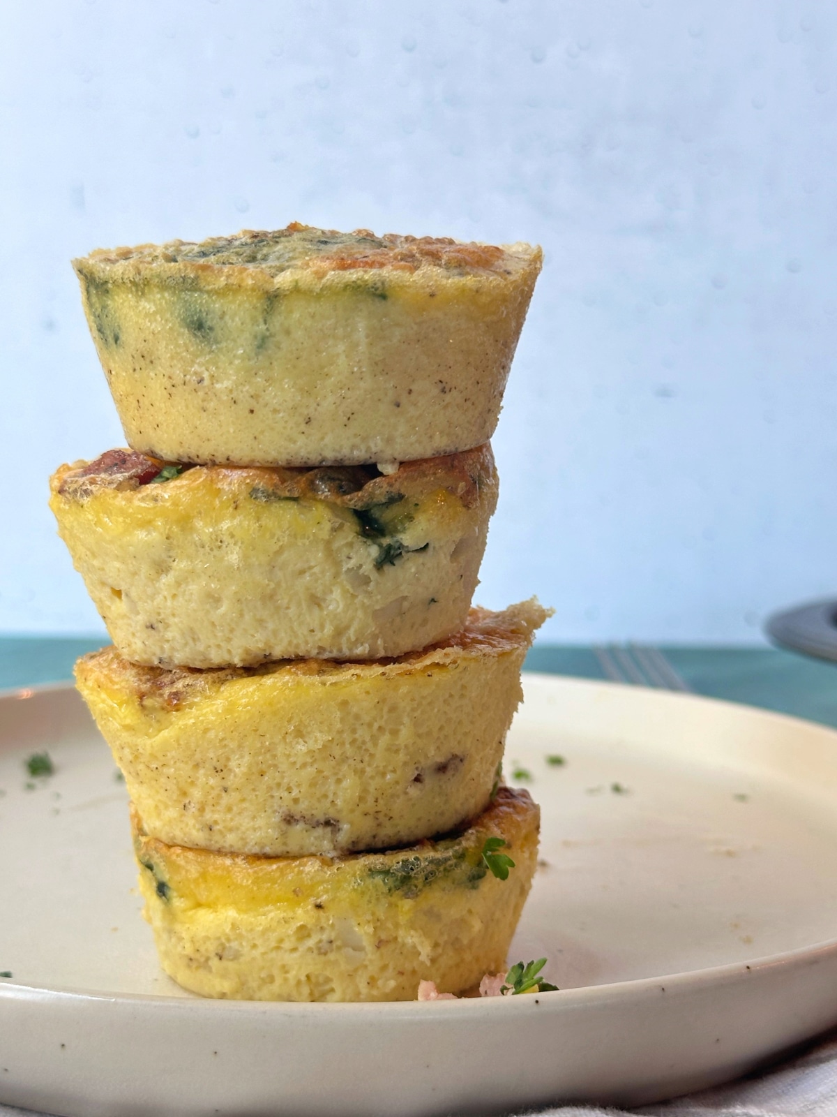 A stack of homemade egg bites on a cream colored plate.