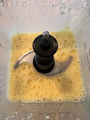A blender cup of blended eggs, seasonings, and cottage cheese.