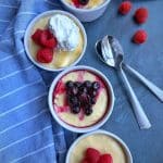 4 Mini Cheesecake Cups lined up with blueberry, raspberry, and whipped cream topping.
