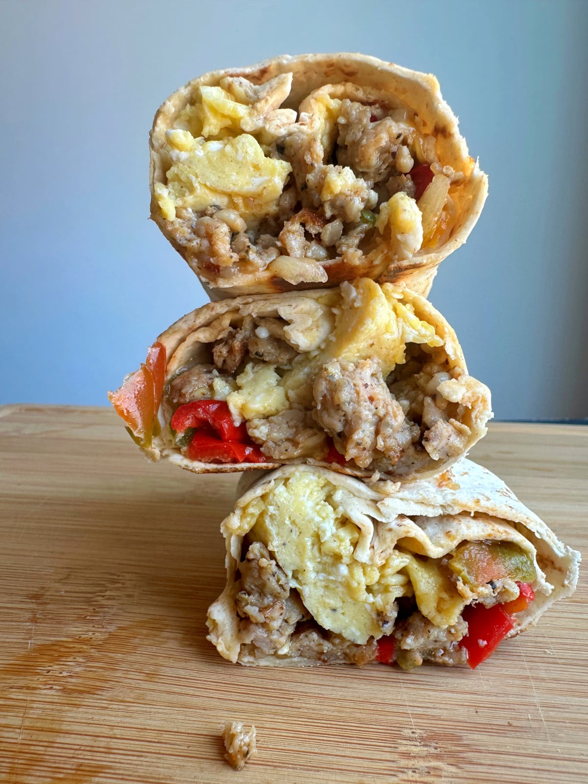 A stack of breakfast burritos cut in half.