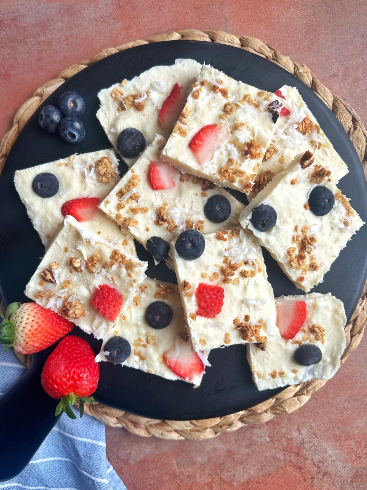 A tray of Yogurt Bark squares with berries and granola on top.