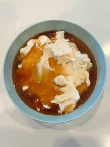 A bowl with Greek yogurt and maple syrup before mixing.