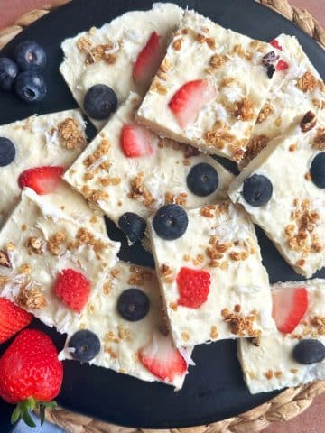 A tray of yogurt bark with fruit and granola, cut into squares.