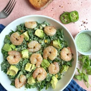 A bowl of shrimp and avocado salad with green goddess dressing on the side.