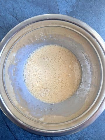 A bowl containing mixed milk, eggs, vanilla, and syrup.