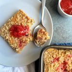 A slice of pb&j baked oats with strawberry jam on top.