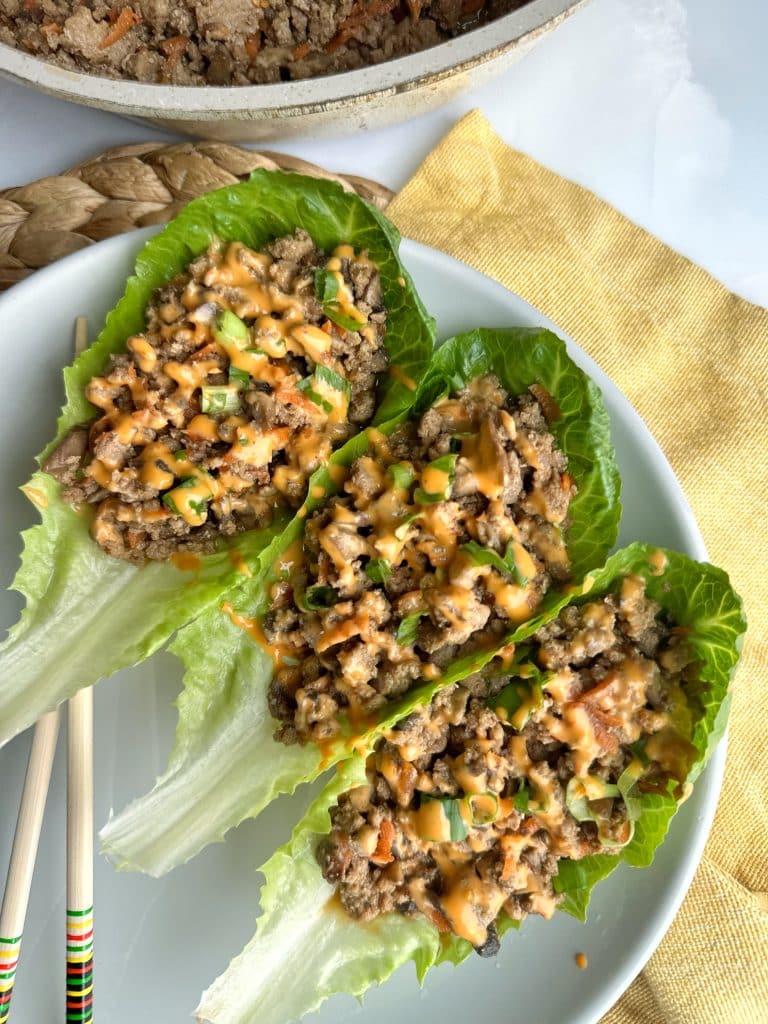 A plate with 3 Asian Chicken Lettuce Wraps.