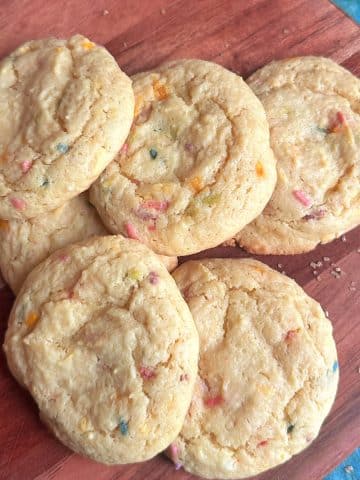A pile of funfetti cookies made of cake mix on a wooden board.