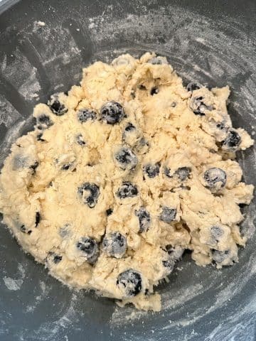 A bowl filled with blueberry biscuit dough.