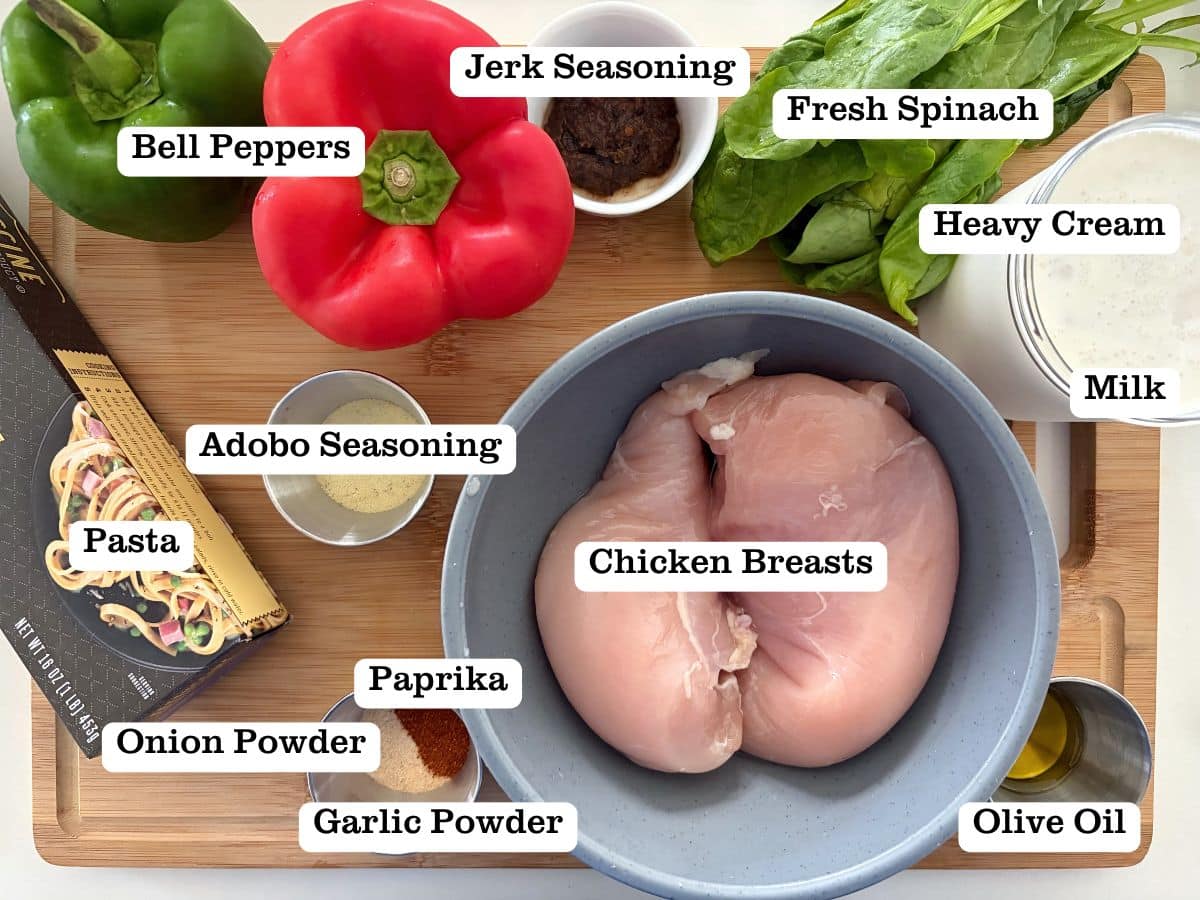 A wooden board with containers of ingredients to make Jerk Chicken Alfredo pasta.
