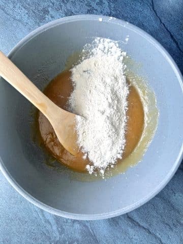 A flour mixture being added to the wet ingredients for blondies.