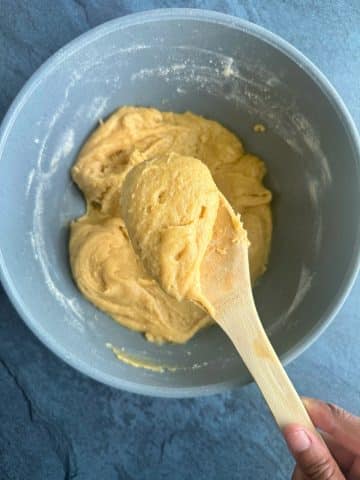 A wooden spoon displaying a scoop of blondie dough.