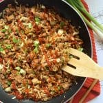 Egg roll filling in a skillet with green onions and a flat wooden spatula - also known as egg roll in a bowl.