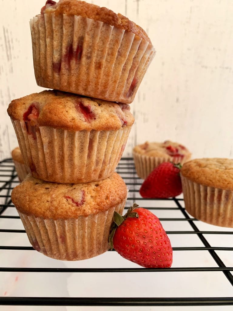 stack of strawberry muffins on a wire rack