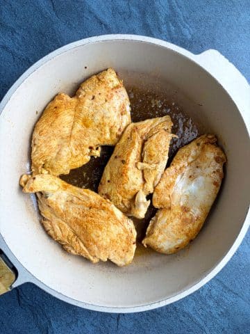 Seared chicken breasts in a skillet.