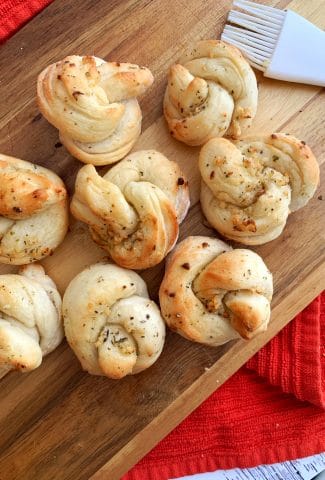 air fried garlic knots on a wooden board with a red background