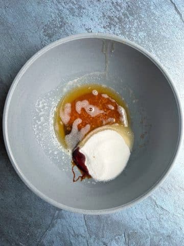 A mixing bowl filled with browned butter, sugar, molasses, and vanilla extract.