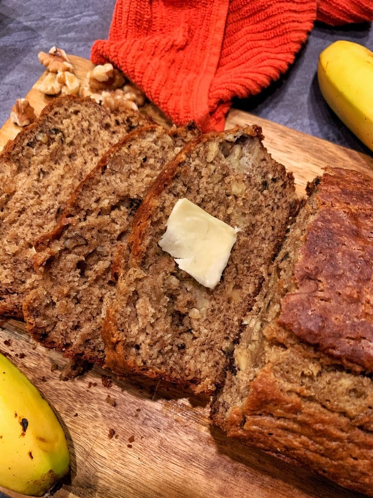 sliced brown butter banana bread on a wooden cutting board