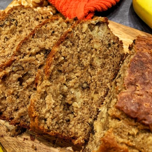 Sliced brown butter banana bread on a wooden cutting board.