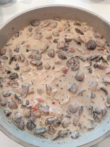 A pan filled with a homemade cream sauce for chicken tetrazzini.