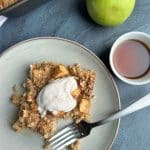 A slice of apple pie baked oats with whipped cream/Greek yogurt on top.