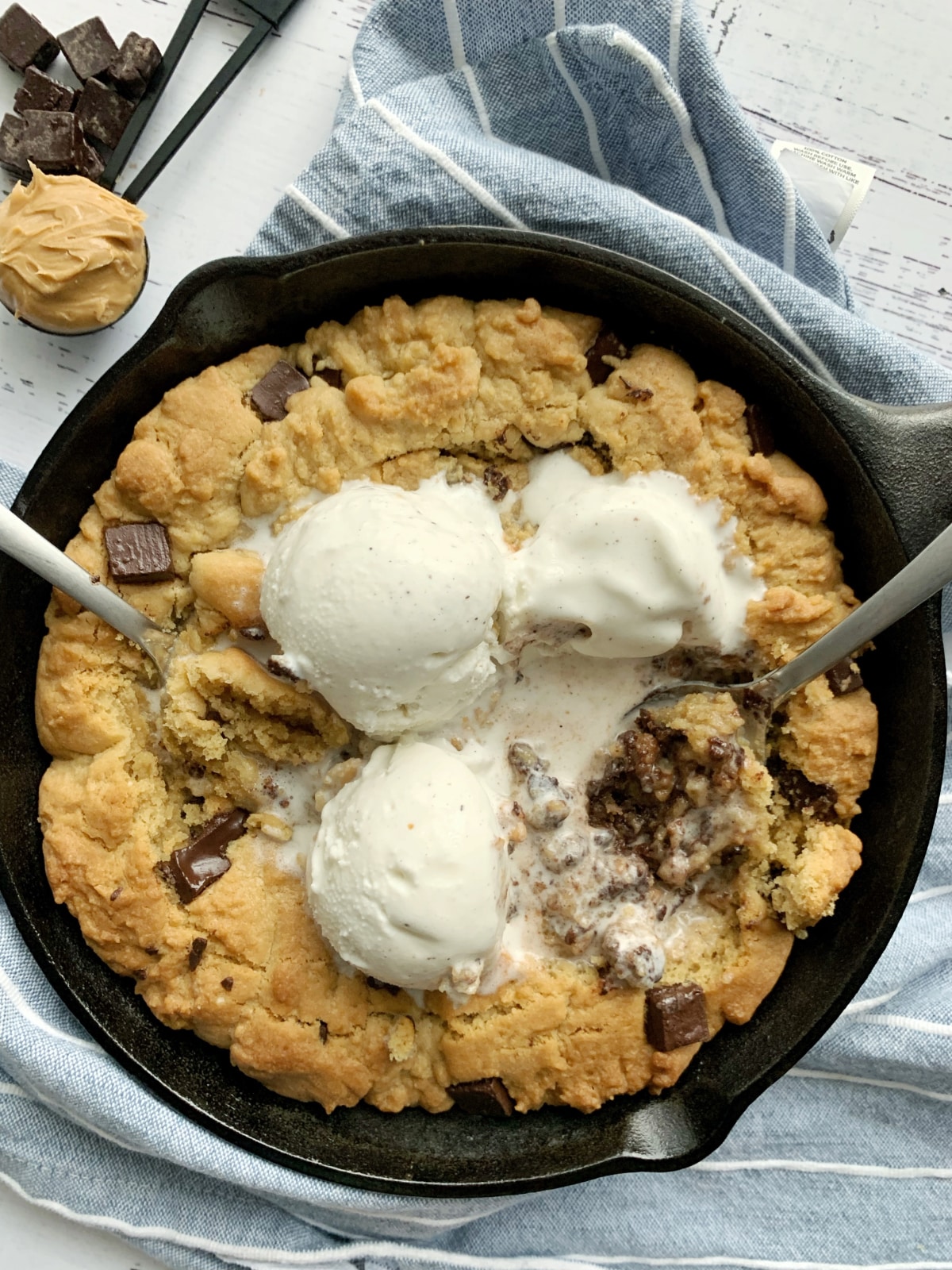 A peanut butter chocolate chip cookie skillet with ice cream on top.