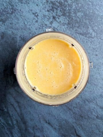 A blender cup filled with peach popsicle liquid.