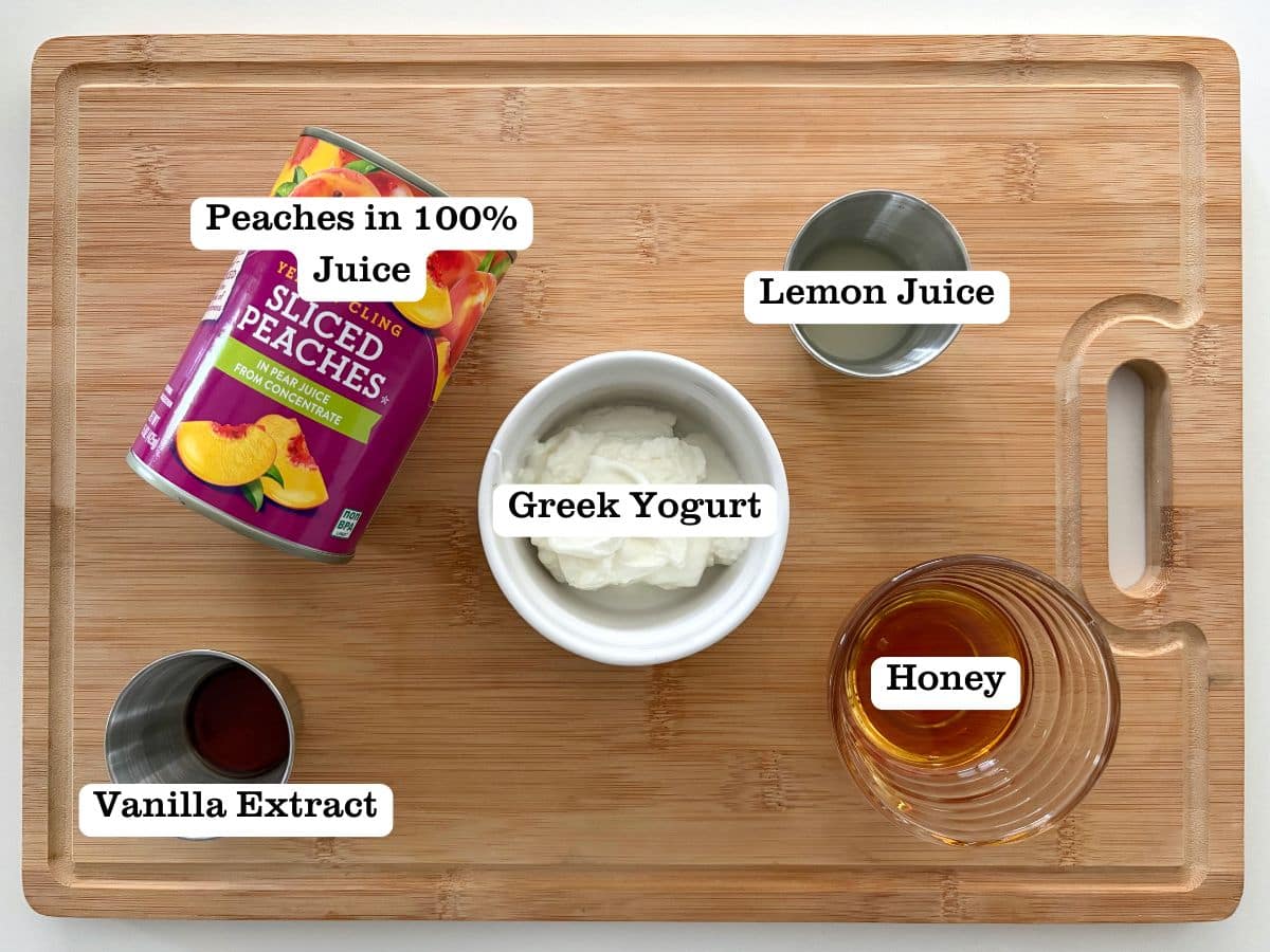 A wooden board with containers of ingredients for peaches and cream popsicles made from scratch.