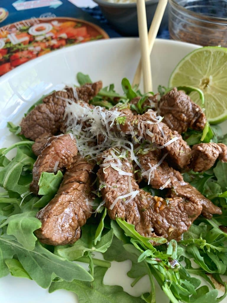 Soy-Lime Beef Stir Fry served over Arugula with a lime.