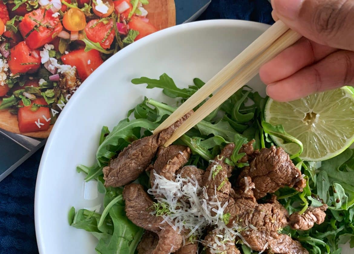 Soy-Lime Beef Stir Fry served over Arugula with Cooking Solo cookbook in the background.