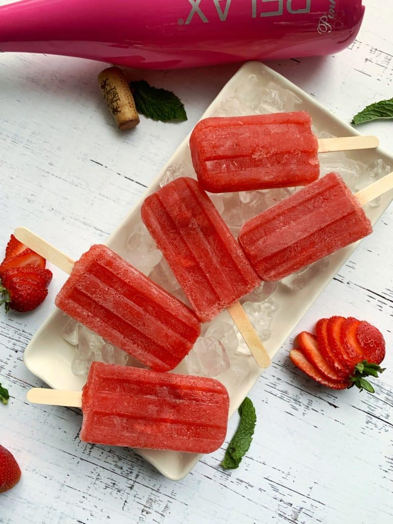 A tray of ice topped with homemade Strawberry Rose popsicles.