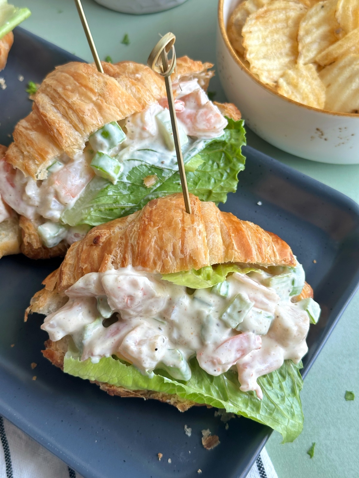 Two croissant sandwiches filled with shrimp seafood salad.