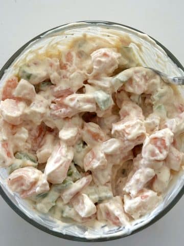 Mayonnaise-based seafood salad in a mixing bowl.