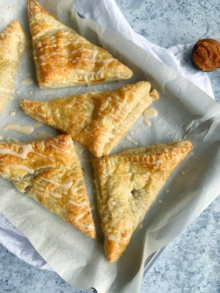 A pan of Roasted Sweet Potato Turnovers with maple glaze.