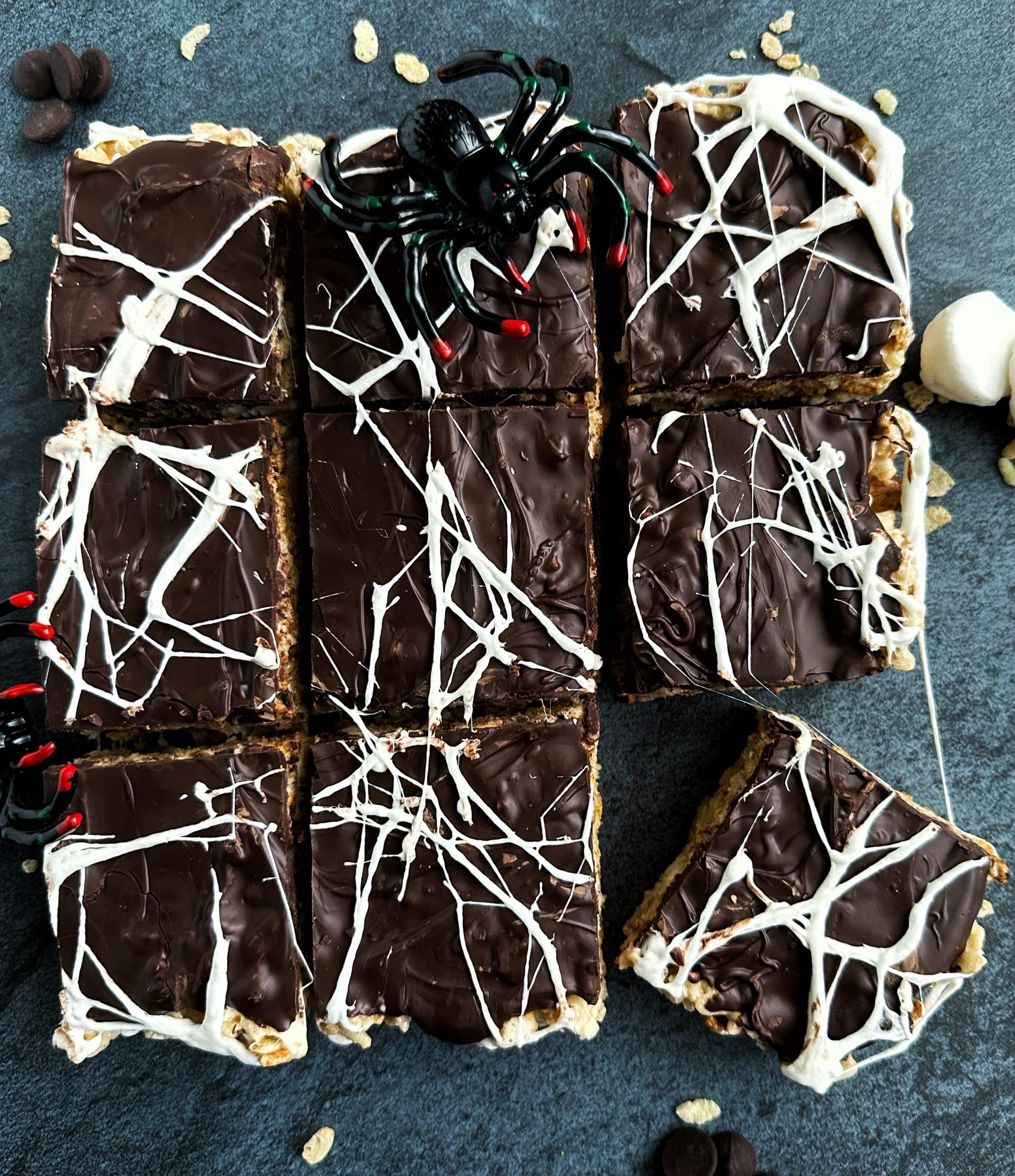 A tray of S'mores flavored Rice Krispie Treats decorated with marshmallow "spider webs" on top.