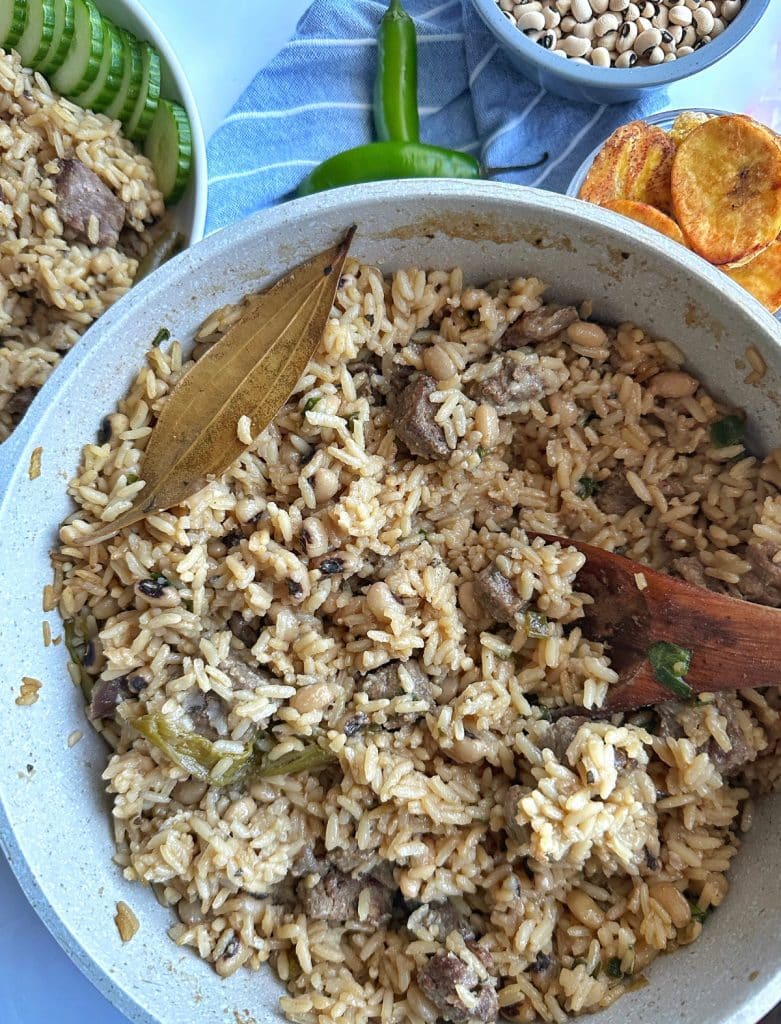 A big pot filled with Guyanese cook cup rice with a Bay leaf on top.