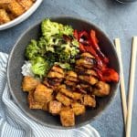 A bowl filled with air fried tofu, rice, and veggies.