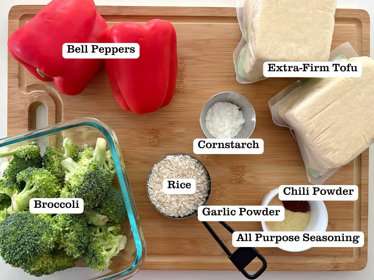 A wooden board with containers of ingredients to make crispy tofu cubes.