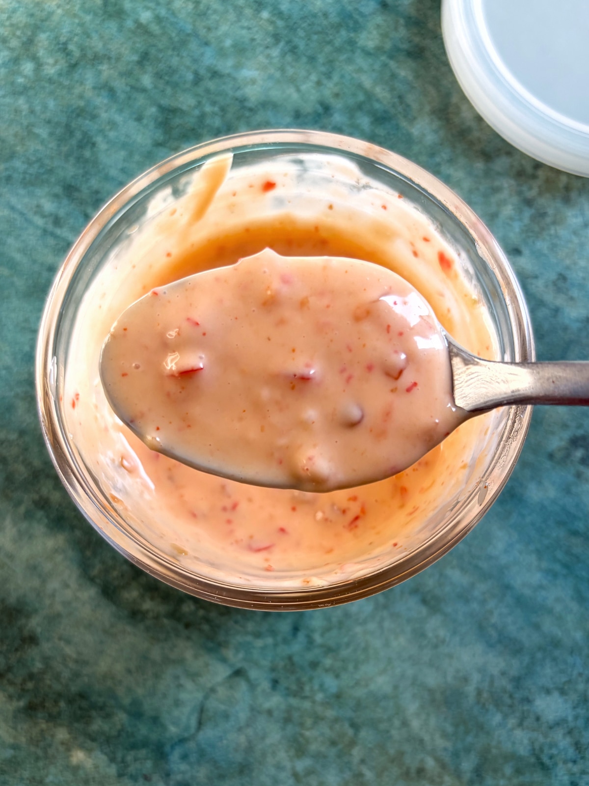 A spoon displaying a bite of homemade bang-bang sauce.