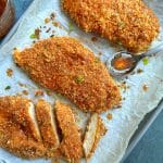 A tray of baked panko-covered hot honey chicken breasts.