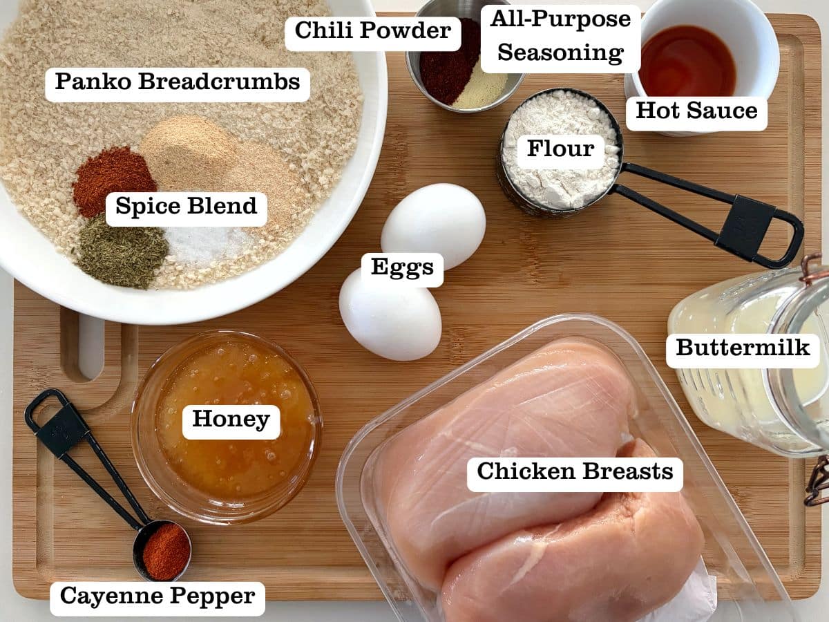 A wooden board with containers of ingredients for baked hot honey chicken.