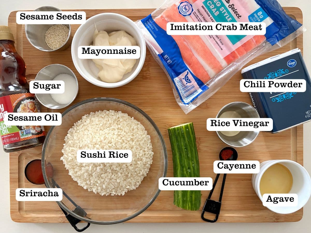 A wooden board with containers of ingredients for crab sushi bake.