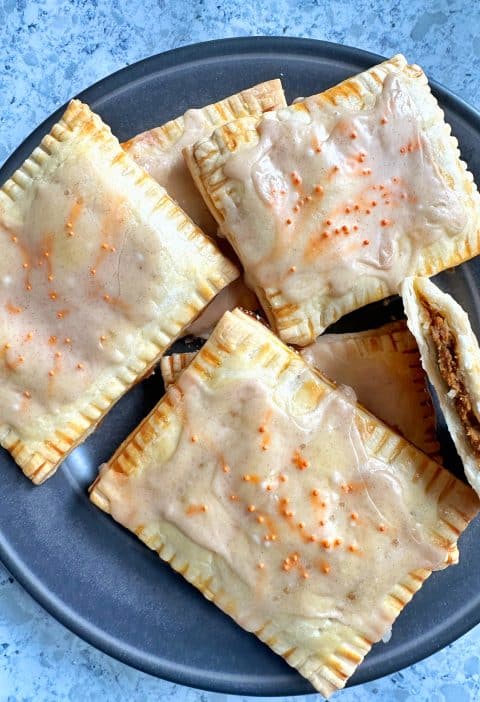 A plate of homemade pumpkin pie pop tarts with maple-cinnamon glaze.