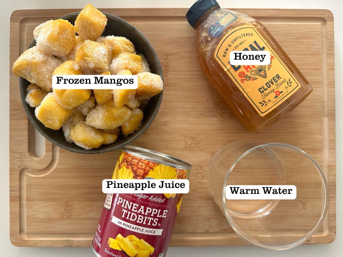 A wooden board containing bowls of ingredients for homemade mango sorbet.