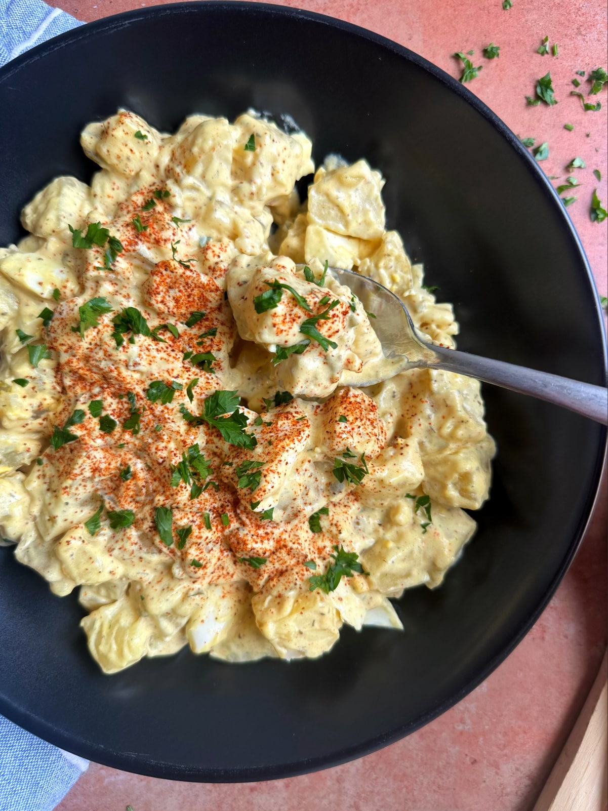 A spoon scooping up a bite of mayo-based potato salad.